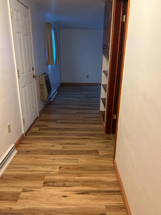 hall with heating unit and light hardwood / wood-style floors