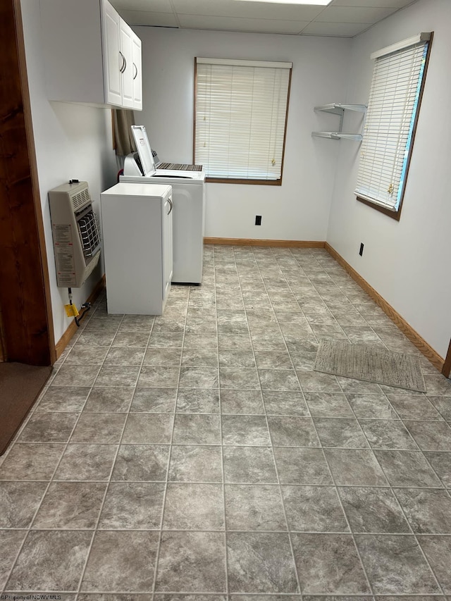 clothes washing area with light tile patterned floors, heating unit, cabinets, and washer and clothes dryer