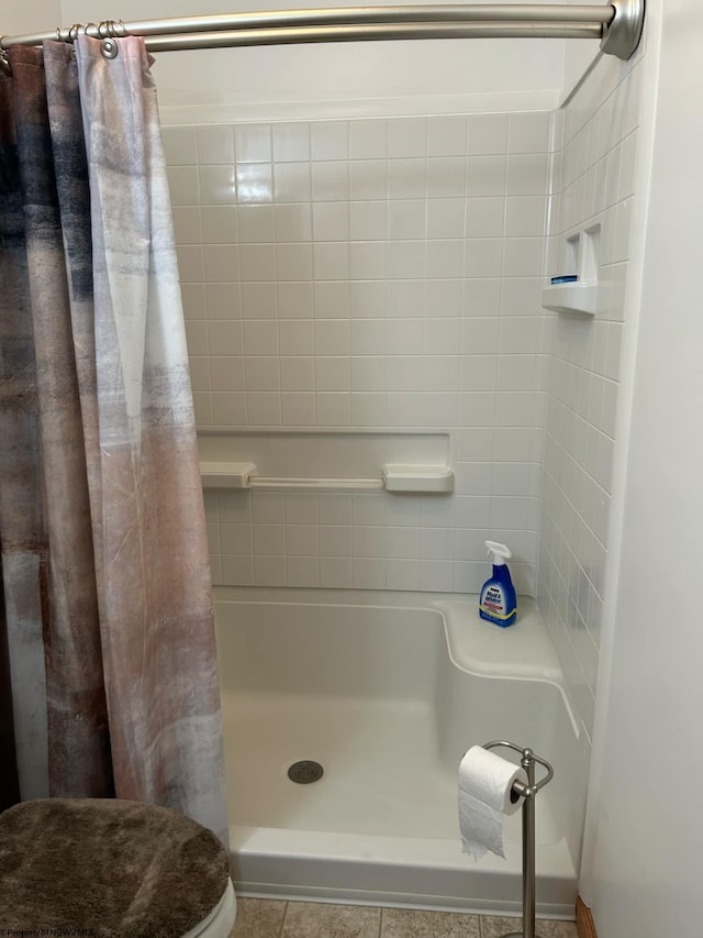 bathroom featuring toilet, walk in shower, and tile patterned flooring