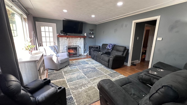 living room featuring crown molding, hardwood / wood-style flooring, and a fireplace