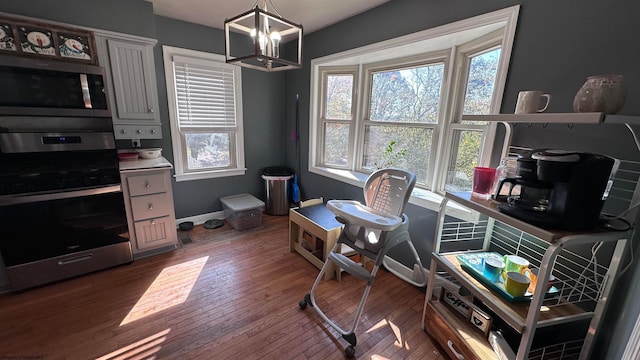 office space featuring an inviting chandelier and dark wood-type flooring