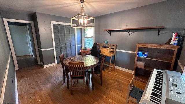 dining space with dark wood-type flooring, a notable chandelier, and heating unit