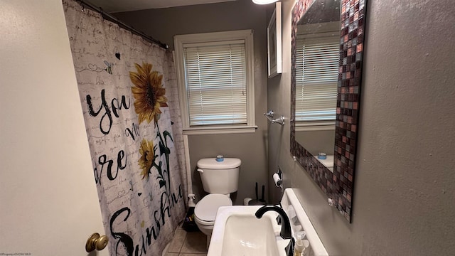 bathroom featuring toilet, tile patterned floors, and walk in shower