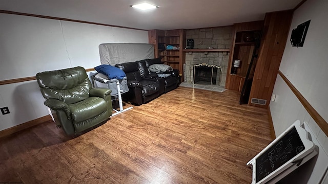 living room featuring a stone fireplace and hardwood / wood-style flooring