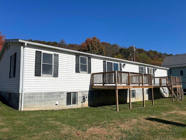 back of property with a yard and a deck