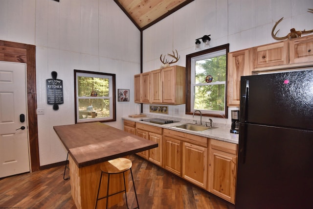 kitchen with sink, wood ceiling, dark hardwood / wood-style flooring, a breakfast bar area, and black refrigerator