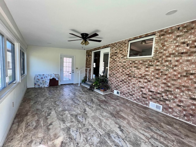 interior space featuring brick wall and ceiling fan