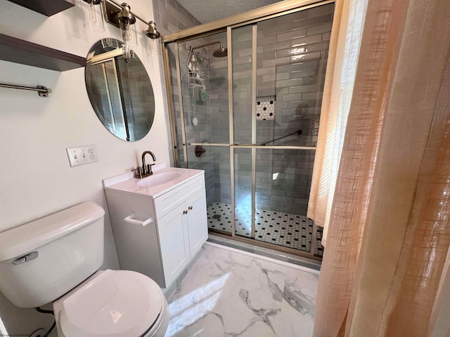 bathroom with vanity, toilet, and a shower with door