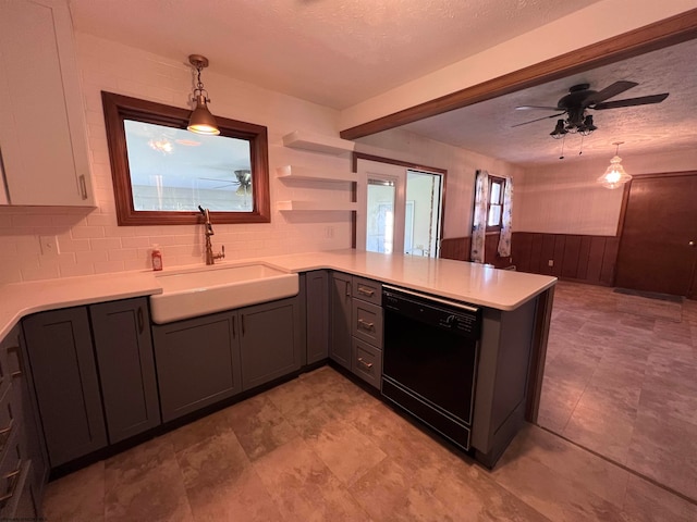 kitchen with kitchen peninsula, a textured ceiling, dishwasher, decorative light fixtures, and sink