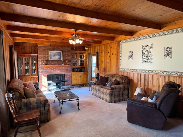 carpeted living room featuring beam ceiling, wood ceiling, wooden walls, and ceiling fan