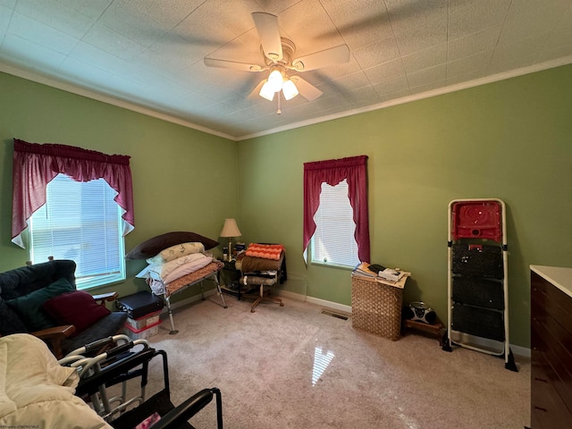 interior space with crown molding, light colored carpet, and ceiling fan