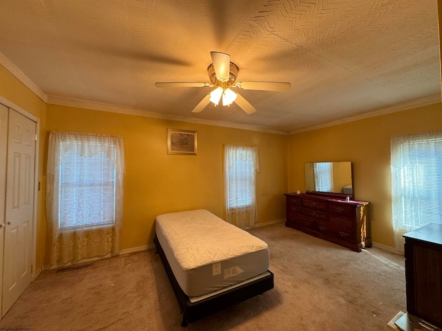 bedroom with ornamental molding, carpet, a textured ceiling, and ceiling fan