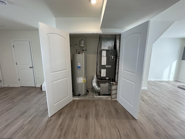 utility room featuring heating unit and water heater