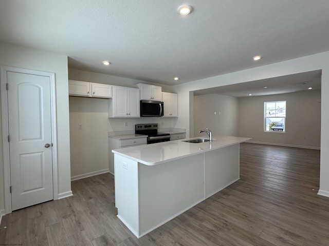 kitchen with a kitchen island with sink, white cabinets, and appliances with stainless steel finishes