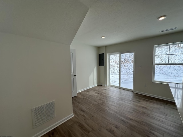 empty room with electric panel and dark hardwood / wood-style floors