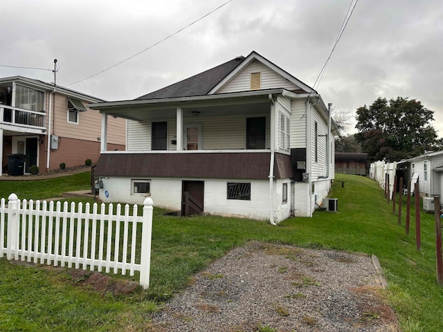 view of front of home with central AC and a front yard