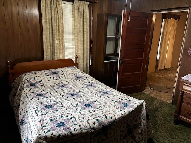 bedroom featuring wood walls and carpet flooring