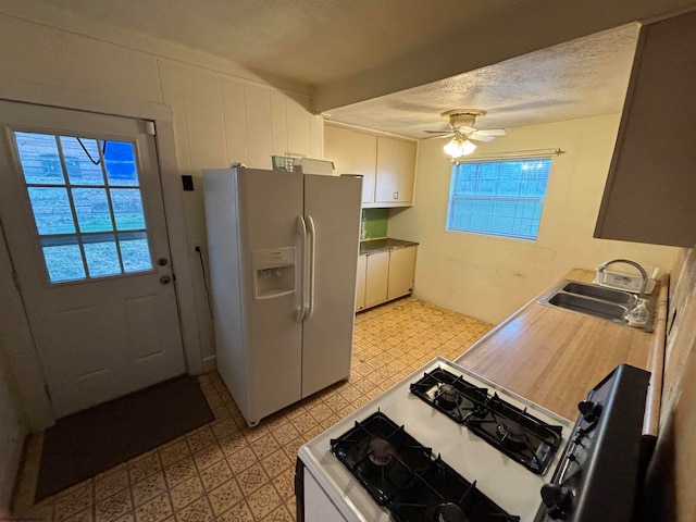 kitchen featuring a wealth of natural light, sink, white cabinets, and white refrigerator with ice dispenser