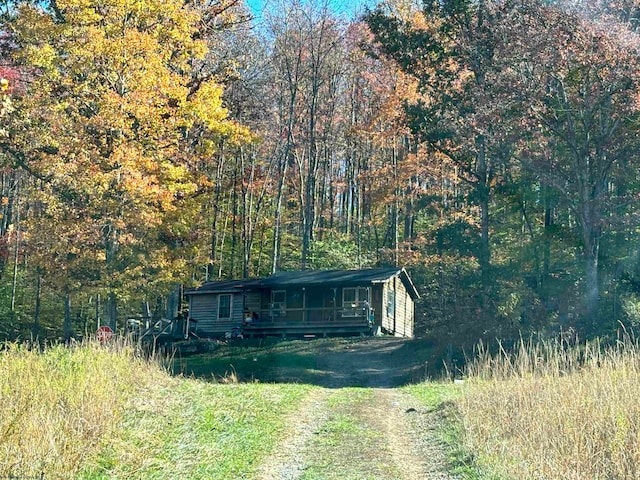 view of front of home featuring driveway and a view of trees