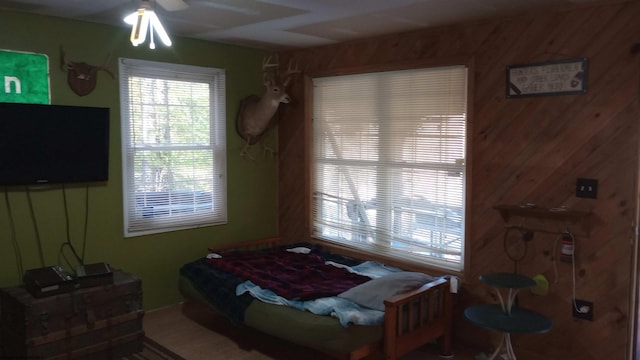 bedroom featuring wooden walls