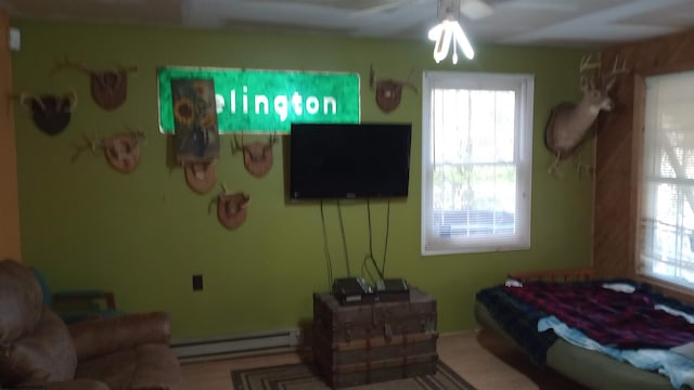 living room featuring ceiling fan, a healthy amount of sunlight, and baseboard heating