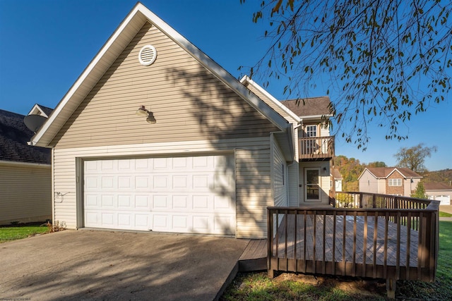 exterior space featuring a wooden deck, a balcony, and a garage