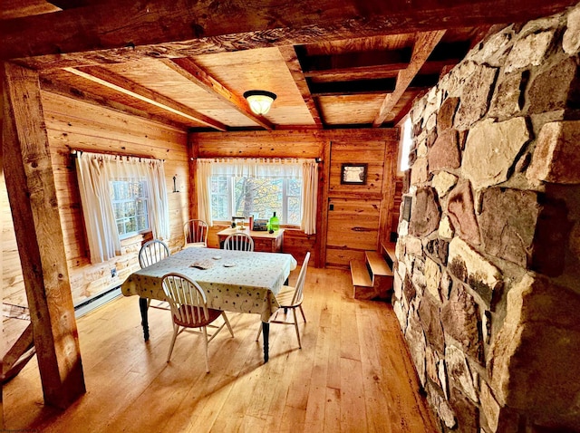 unfurnished dining area featuring wood ceiling, wood walls, beamed ceiling, and light wood-type flooring