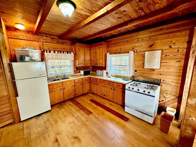 kitchen with beamed ceiling, light hardwood / wood-style flooring, a wealth of natural light, and white appliances