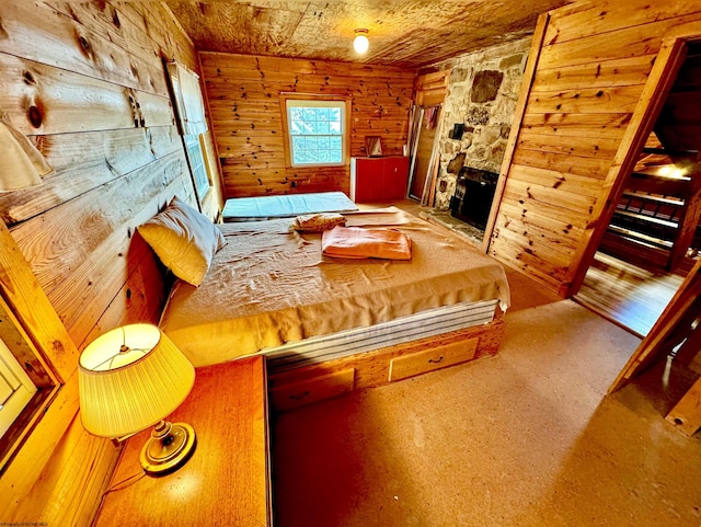 unfurnished bedroom featuring a fireplace, carpet flooring, and wood walls