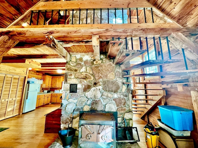 unfurnished living room with a wealth of natural light, lofted ceiling with beams, light hardwood / wood-style flooring, and wooden ceiling