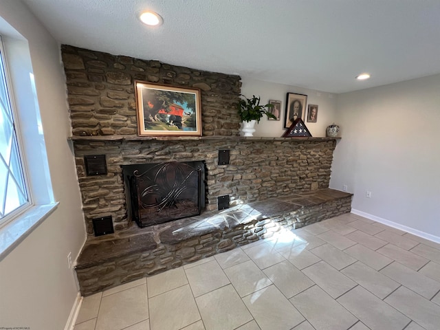 tiled living room featuring a textured ceiling and a fireplace