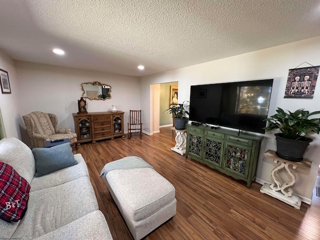 living room featuring a textured ceiling and dark wood-type flooring