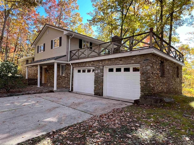 view of side of property featuring a balcony and a garage