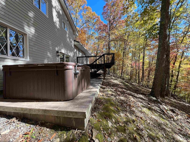 exterior space with a hot tub and a deck