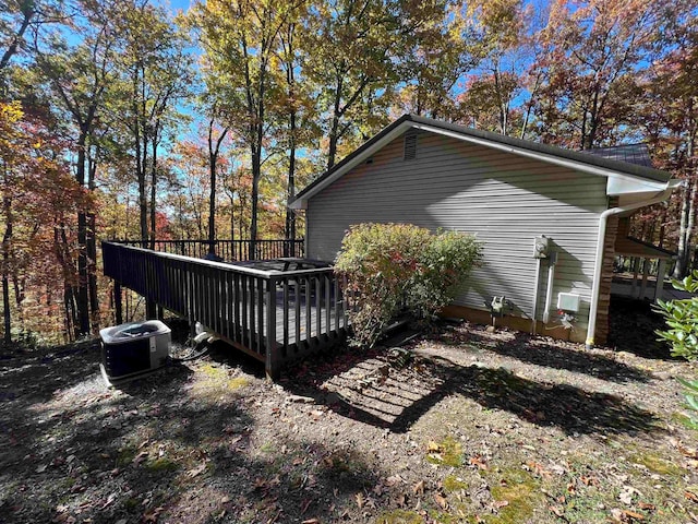 view of property exterior with a deck and central air condition unit