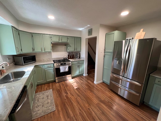 kitchen featuring dark wood-type flooring, appliances with stainless steel finishes, sink, and green cabinetry