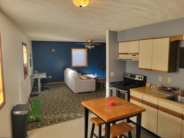 kitchen featuring a textured ceiling, ceiling fan, sink, and electric stove