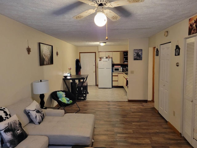 living room featuring ceiling fan, a textured ceiling, and hardwood / wood-style floors