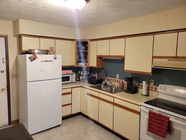 kitchen featuring cream cabinets, range hood, sink, a textured ceiling, and white appliances