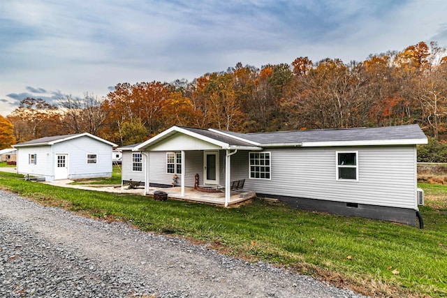 view of front of house with crawl space, a porch, gravel driveway, and a front yard