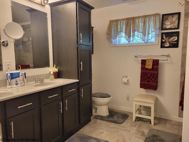 bathroom featuring vanity, tiled shower, and toilet