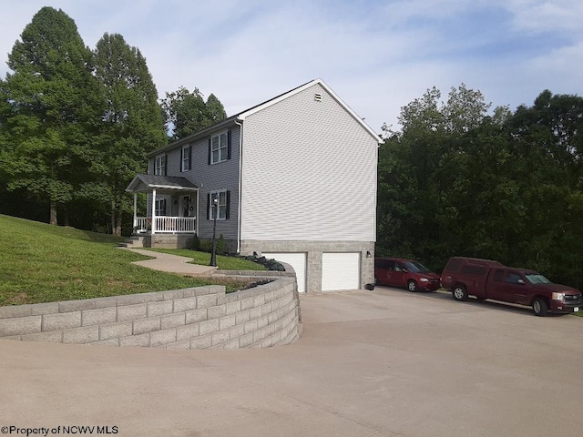 view of property exterior featuring a lawn, a porch, and a garage