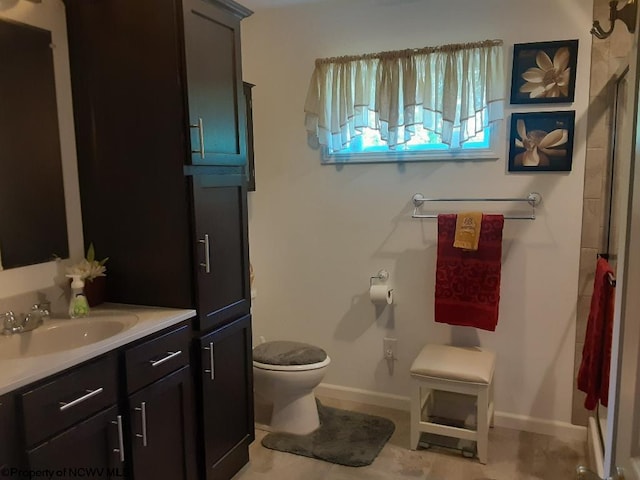 bathroom with toilet, walk in shower, vanity, and tile patterned flooring