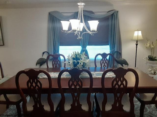 carpeted dining room with crown molding and a notable chandelier