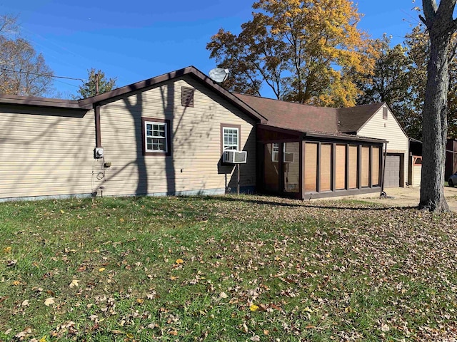 view of home's exterior featuring a yard, cooling unit, and a garage