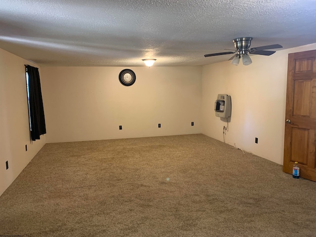 carpeted spare room featuring a textured ceiling, heating unit, and ceiling fan