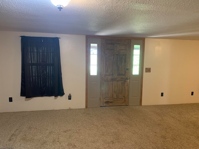 entryway featuring carpet flooring and a textured ceiling