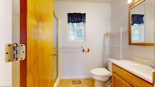 bathroom with vanity, toilet, and a shower with door