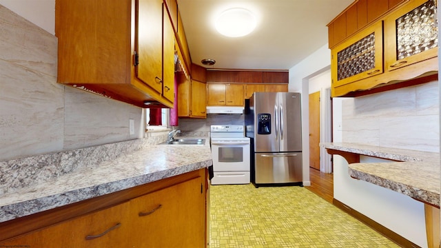 kitchen featuring light hardwood / wood-style flooring, backsplash, sink, stainless steel fridge, and white electric stove