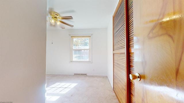 empty room featuring light carpet and ceiling fan